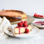 Homemade classic cheesecake with fresh berry topping on a white plate