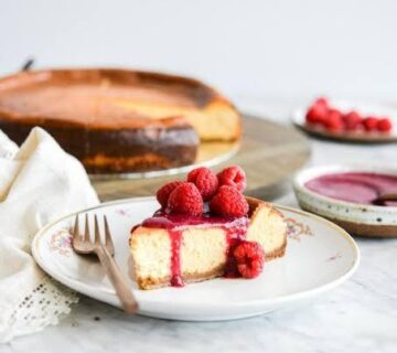 Homemade classic cheesecake with fresh berry topping on a white plate