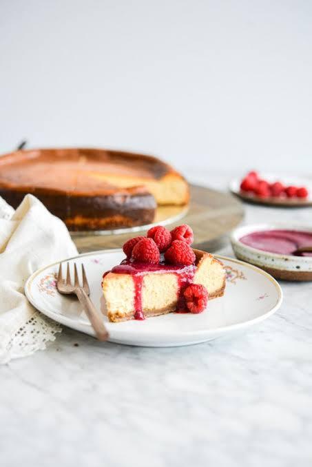 Homemade classic cheesecake with fresh berry topping on a white plate